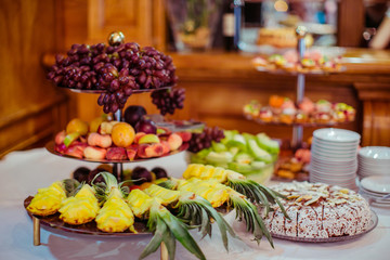 Grape and ananas lie on the tired dish on the buffet