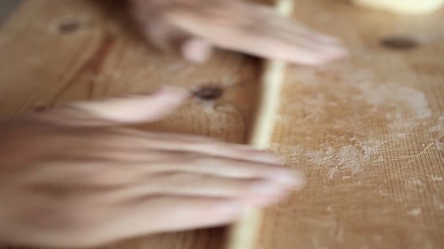 Uomo mezza et&agrave; che sta facendo la pasta fatta in casa su un tagliere di legno.