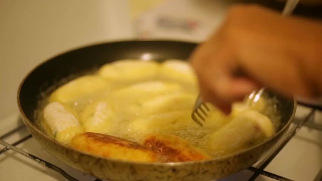 Crocchette di patate che stanno friggendo in una padella con olio bollente. 