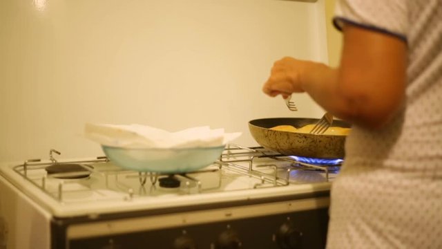 Donna cuoca in casa che sta cucinando le crocchette di patate ripiene in cucina. 