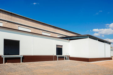 Fototapeta na wymiar Industrial warehouse with office unit with blue sky