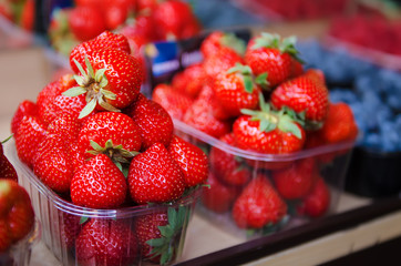 Fresh strawberry at market in plastic boxes, local food healthy background