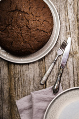 Fototapeta premium Healthy chocolate cake with beet on a gray plate with the effect of craquelure on the old wooden background. Selective focus 