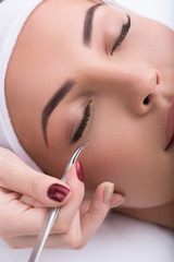 Obraz premium Beautiful young woman during eyelash extension