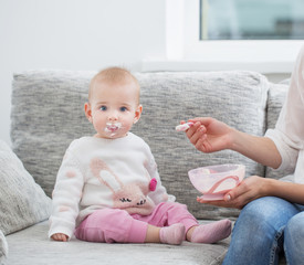 Mom feeding baby indoor