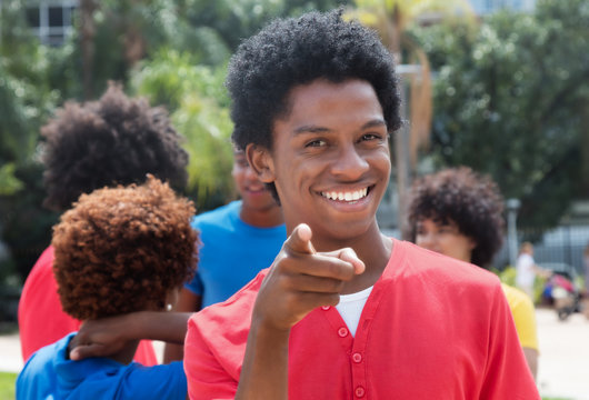 Pointing young african american man with friends