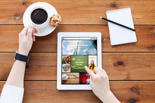 close up of woman with tablet pc on wooden table