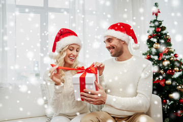 happy couple at home with christmas gift box