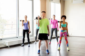 Fototapeta premium group of smiling people exercising with dumbbells