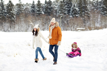 Fototapeta na wymiar happy family with sled walking in winter forest
