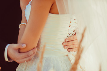 Groom holds his hands on bride's waist delicately