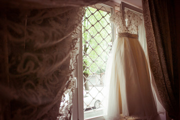 Wedding dress hangs on the high window