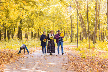 Happy young family spending time together outside in autumn nature.