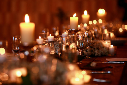 A blurred picture of candles burning over the empty glasses