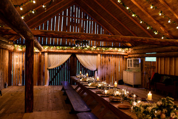 Long table stands in the wooden storage decorated for a wedding