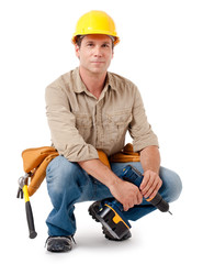 Full-length construction worker contractor carpenter squatting kneeling in hard hat with tools...