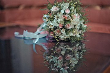 White and pink wedding bouquet lies on the glass table © pyrozenko13