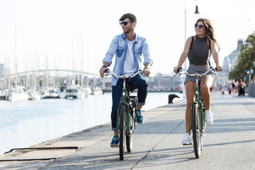 Happy young couple cycling in the city. © nenetus