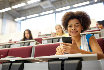 african student girl with smartphone at lecture