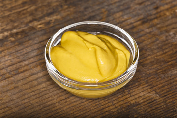 bowl with mustard on wooden board