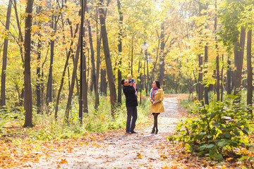 Obraz premium love, parenthood, family, season and people concept - smiling couple with baby in autumn park