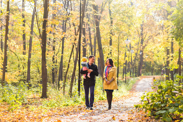 Fototapeta premium love, parenthood, family, season and people concept - smiling couple with baby in autumn park