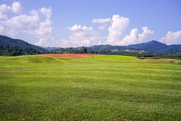 green field and blue sky with big clouds