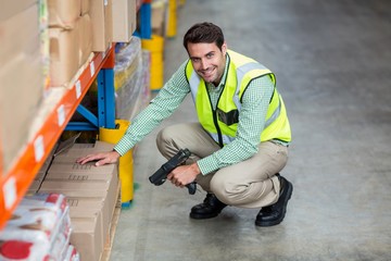 Portrait of smiling warehouse worker scanning box