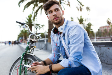 Handsome young man using his mobile phone in the street.