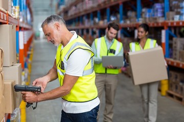 Warehouse worker scanning box - Powered by Adobe