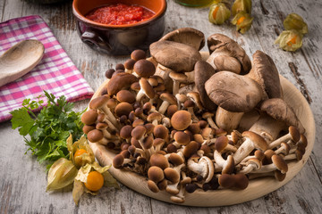 Misto di funghi freschi su un piatto tondo in legno su un tavolo 