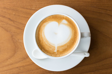 Top view coffee cup latte art on wood table.