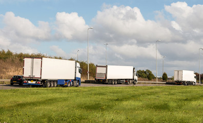 Fototapeta na wymiar Three lorries in queue on the busy road