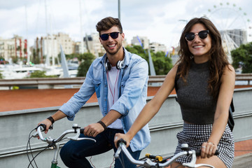 Happy young couple cycling in the city.