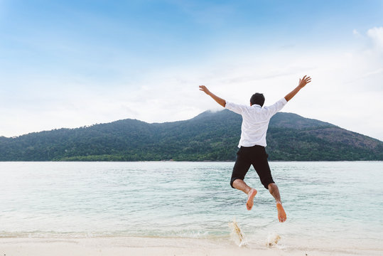 Happiness of businessman jumping relax on beautiful sea beach at