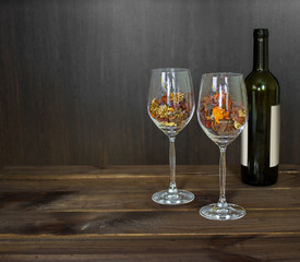Autumn leaves in a wine glass and wine bottle on wooden table background