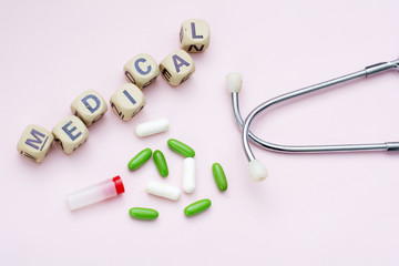 Pink background inscription medical, pills and stethoscope