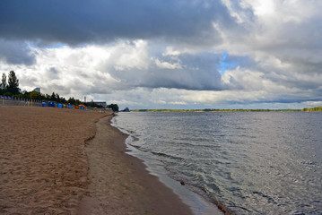 Samara, city beach on the shores of the Volga River at cloudy autumn day, beautiful cumulus clouds