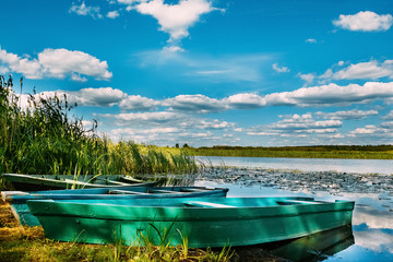 Naklejka na ściany i meble Landscape with boats and the river. Cloudy sky in the background