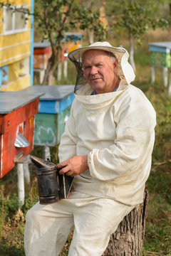 beekeeper sitting on a tree near the hive