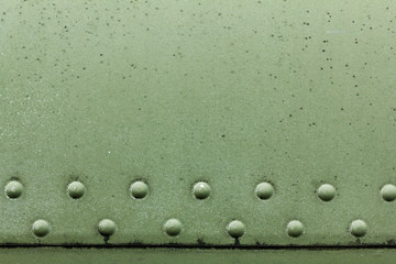 Old painted metal background detail of a military aircraft, surface corrosion.