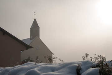 Fototapeta na wymiar Le clocher de l'église Saint-Louis de La Vancelle dans le broui