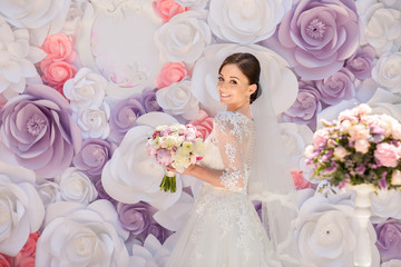 Wedding ceremony. Portrait of beautiful bride on paper flowers wedding arch background