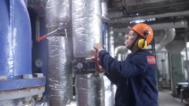 boiler heating system inspection. boiler maintenance or gas equipment at the plant. Modern pipes intertwined, and consortium, technologically. Perhaps the oil derrick. Work turns the pipe valve