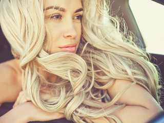 Atmospheric portrait of beautiful blonde in car - 123936936