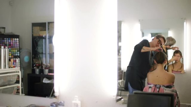 The stylist works in the reflection of the mirror