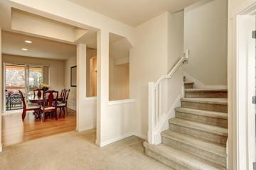 Beige hallway with staircase leading upstairs