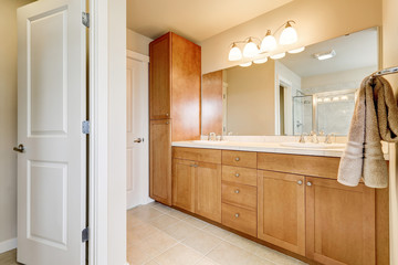 View of bathroom storage units, two sinks and large mirror