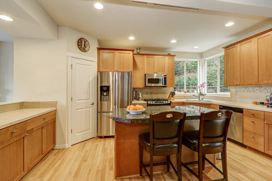Bright wooden kitchen room with stainless steel appliances