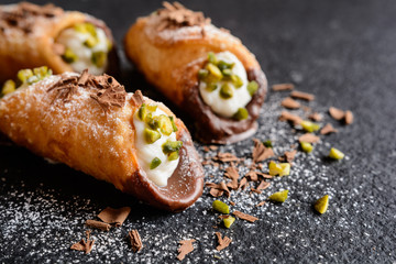 Traditional Sicilian cannoli stuffed with ricotta and pistachios - obrazy, fototapety, plakaty